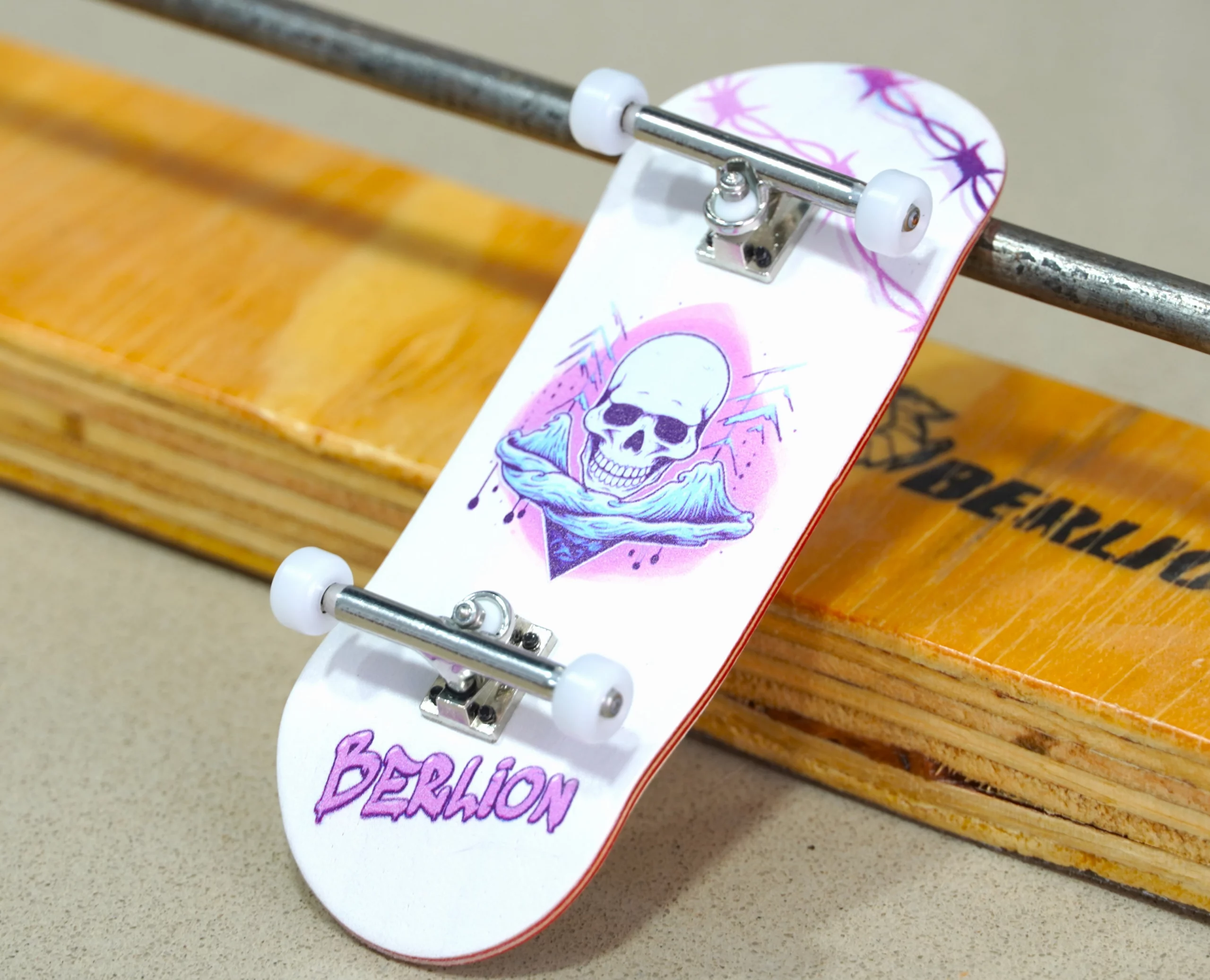 Fingerboard Berlion realizando trucos sobre rampa morada.